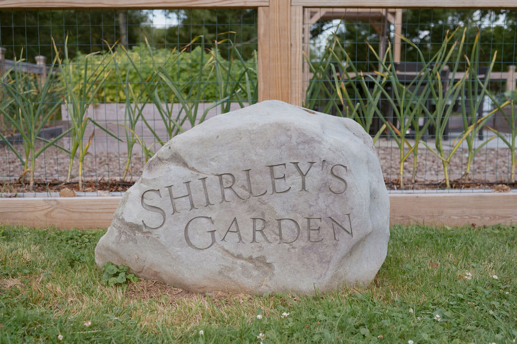 Photo of large rock with this text on it: Shirley's Garden